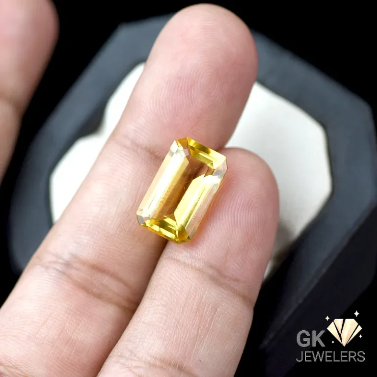 Emerald-cut yellow citrine gemstone on a person's finger