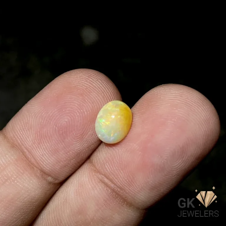 Vibrant yellow opal gemstone cradled between fingertips