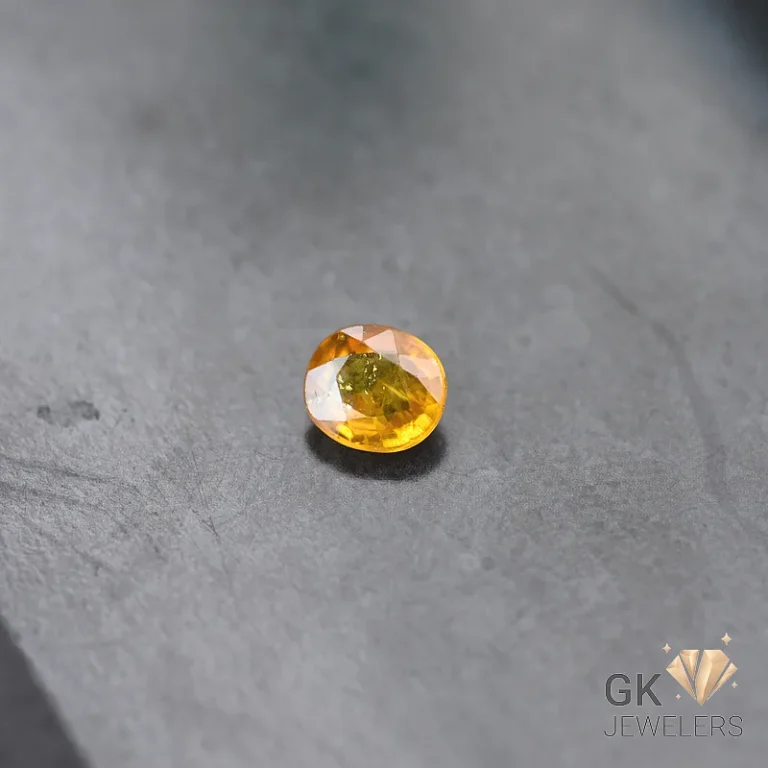 Oval-cut citrine gemstone on a gray stone surface