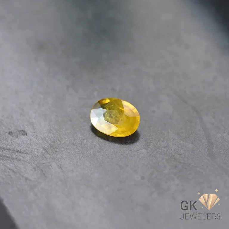 Yellow citrine gemstone oval cut on gray stone surface