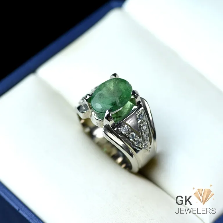 Emerald ring with sterling silver band and triangular diamond details