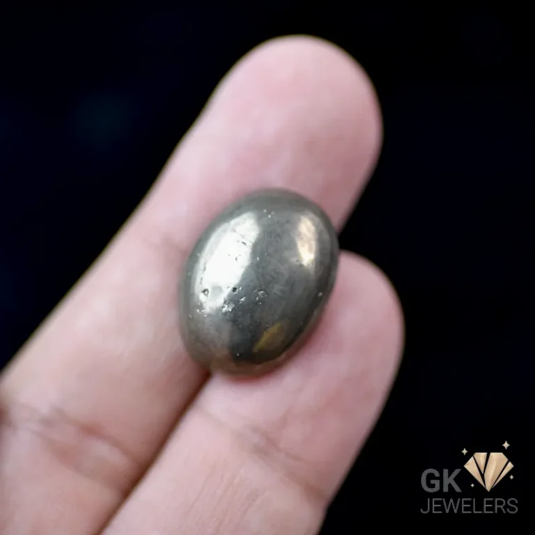 Person holding a polished dark gray oval gemstone