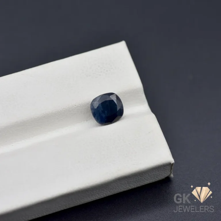 Cushion cut sapphire gemstone on white jewelry display