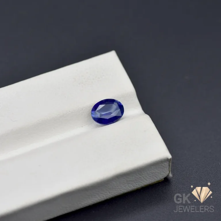 Oval-cut blue sapphire gemstone on white jewelry display