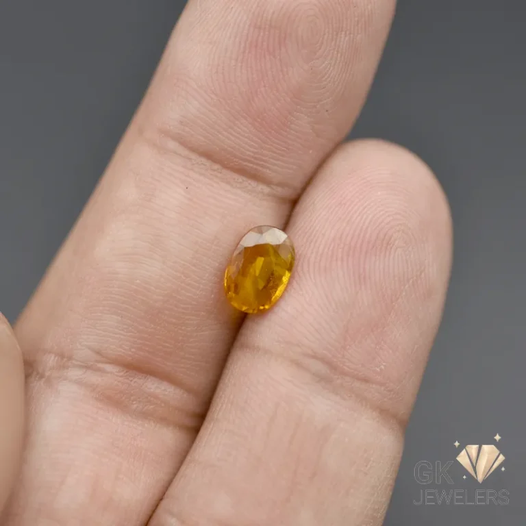 Golden citrine gemstone held between fingers