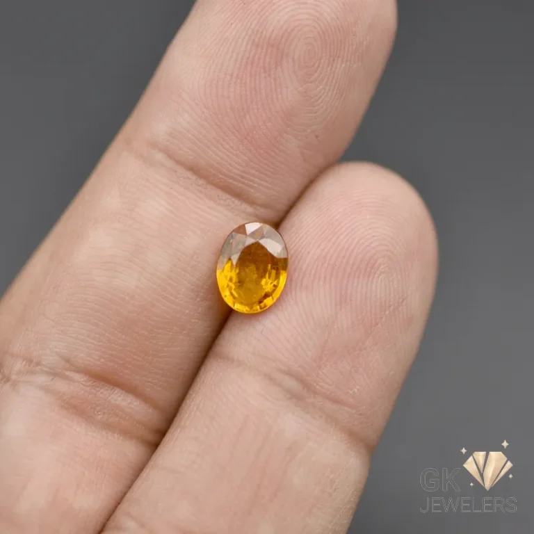 Oval-cut yellow citrine gemstone held between fingers
