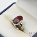 Red opal gemstone set in handmade silver ring displayed in jewelry box