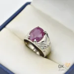 Oval-cut natural ruby gemstone weighing 6 carats, set in a handmade silver ring with intricate details, displayed in a cream-colored jewelry box