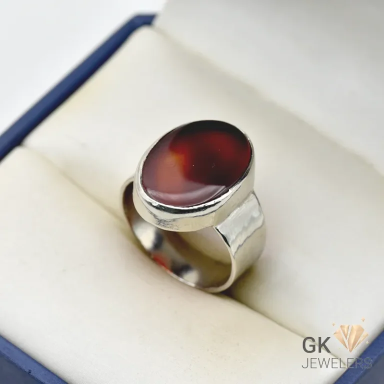 Oval dark brown agate gemstone set in a handmade silver ring, displayed in a jewelry box with white interior