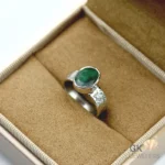 Silver ring featuring a vibrant oval-cut emerald gemstone from Zambia, set in handmade 925 sterling silver with translucent green color