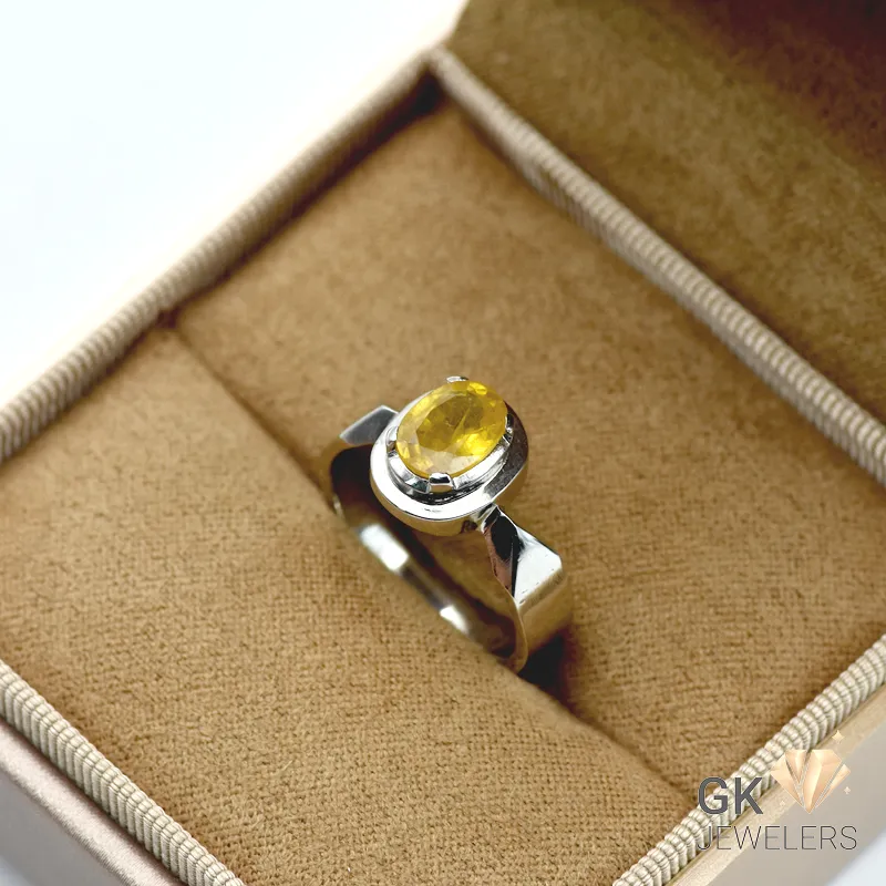 Oval yellow sapphire gemstone set in a handmade sterling silver ring with transparent crystal structure