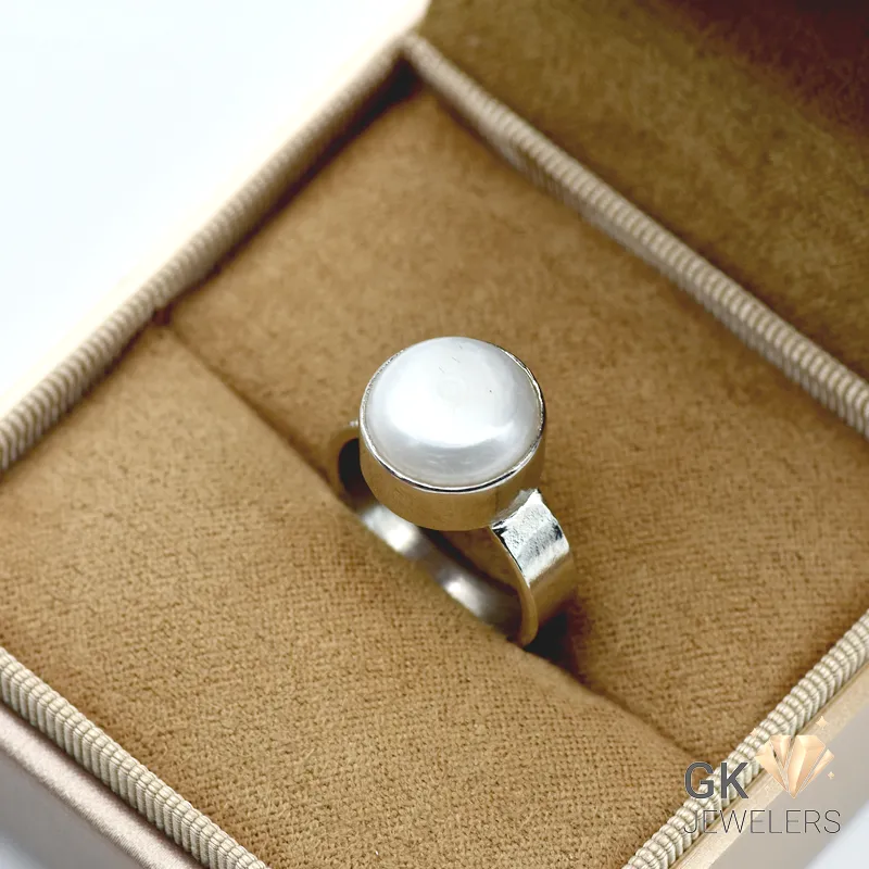 Handmade silver ring featuring a round white natural pearl from Africa, set in a simple bezel with a small square-cut diamond accent on the band
