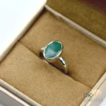 Silver ring with oval emerald gemstone from Zambia, set in handmade mount, displayed in jewelry box