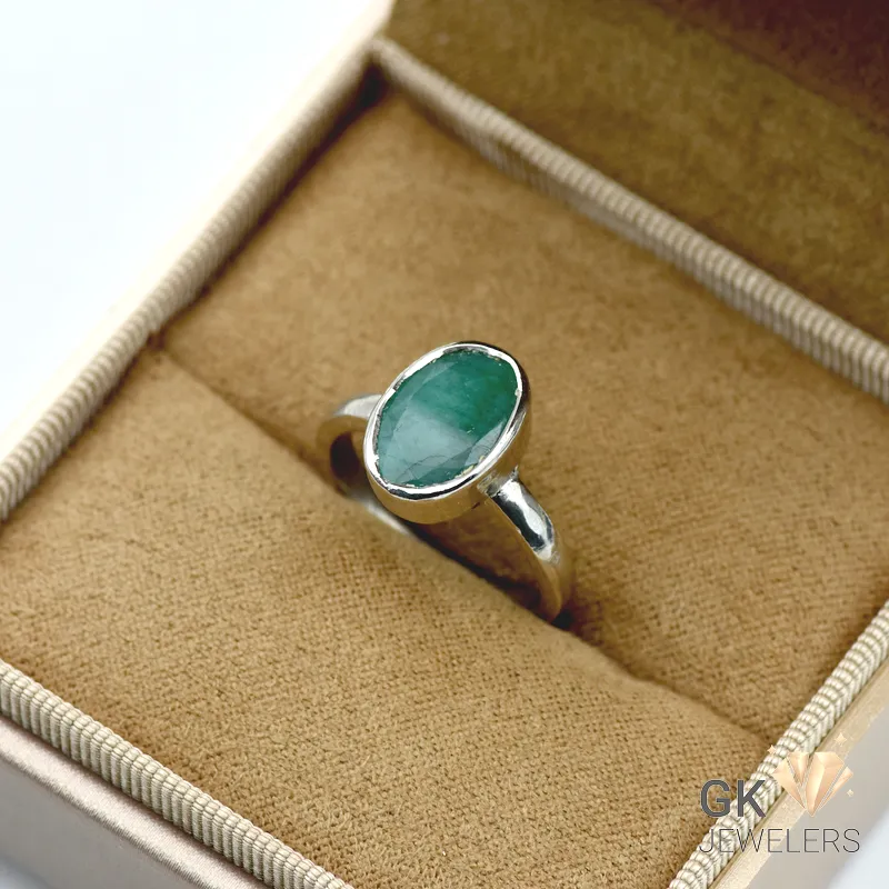 Silver ring with oval emerald gemstone from Zambia, set in handmade mount, displayed in jewelry box