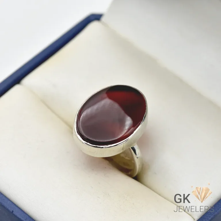 Oval maroon Yamani Agate gemstone set in a handmade silver ring, displayed in a jewelry box