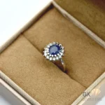 Oval blue sapphire gemstone surrounded by diamond halo in handmade sterling silver ring, Sri Lankan origin