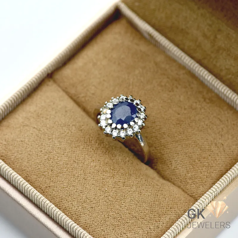 Oval blue sapphire gemstone surrounded by diamond halo in handmade sterling silver ring, Sri Lankan origin