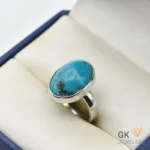 Sterling silver ring featuring a 12-carat oval turquoise gemstone with natural inclusions and light blue color