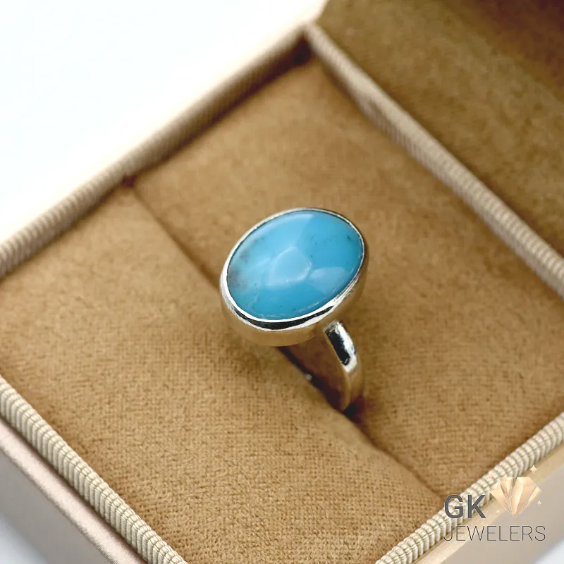 Oval-cut natural turquoise gemstone set in a sterling silver ring with handmade craftsmanship, displaying vibrant blue color and opaque transparency