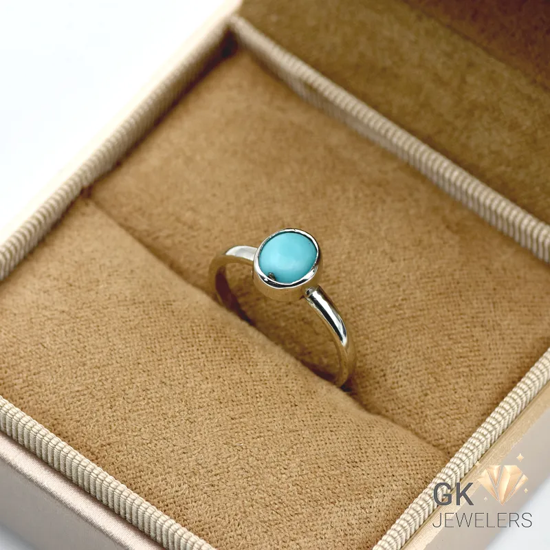Silver ring featuring a round-cut natural turquoise stone from Iran, set in handmade sterling silver with an opaque blue color