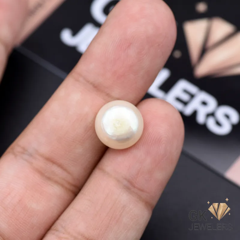 White natural pearl gemstone, 8.25 carats, held between fingers against a black jewelry advertisement background
