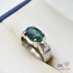 Silver ring featuring an oval-cut green Ethiopian opal gemstone with a triangular diamond accent