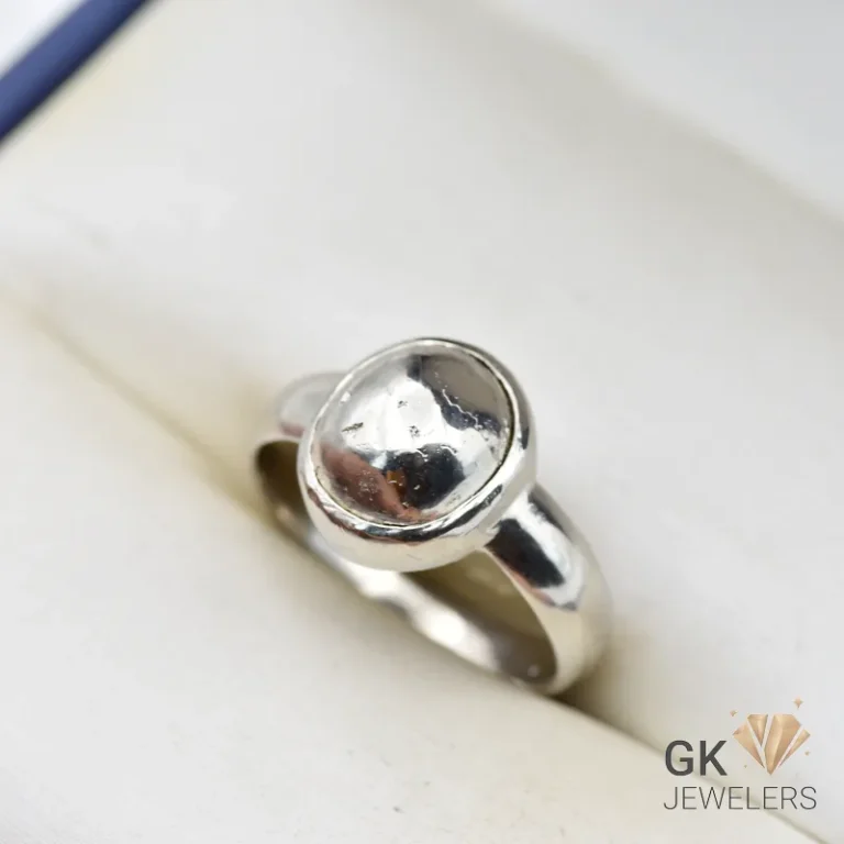 Oval pyrite gemstone set in handmade silver ring, size 19, with metallic luster on a white background