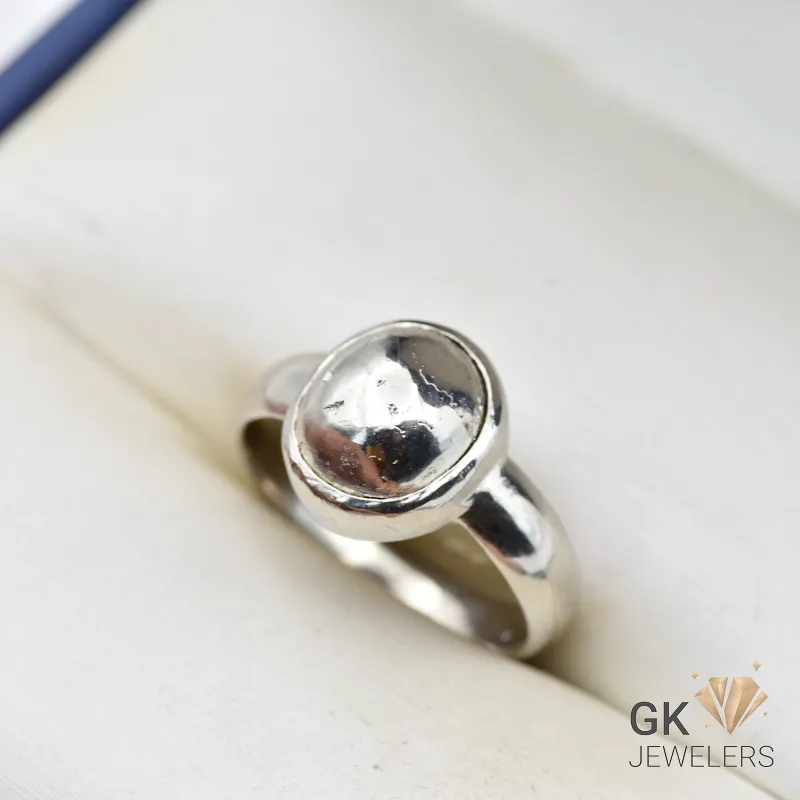 Oval pyrite gemstone set in handmade silver ring, size 19, with metallic luster on a white background