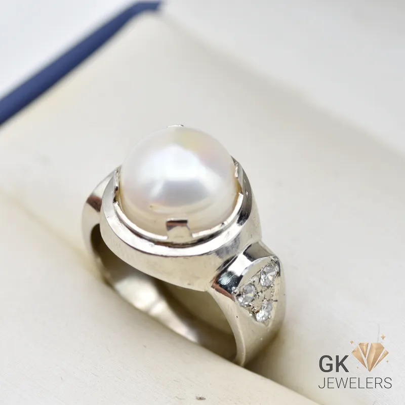Handmade silver ring featuring a lustrous white round pearl from Africa, set in a decorative silver band with small diamonds
