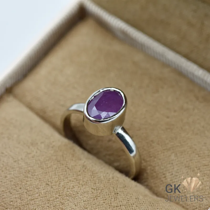 Silver ring featuring a pinkish-red oval-cut ruby gemstone from Madagascar, set in a handmade bezel setting