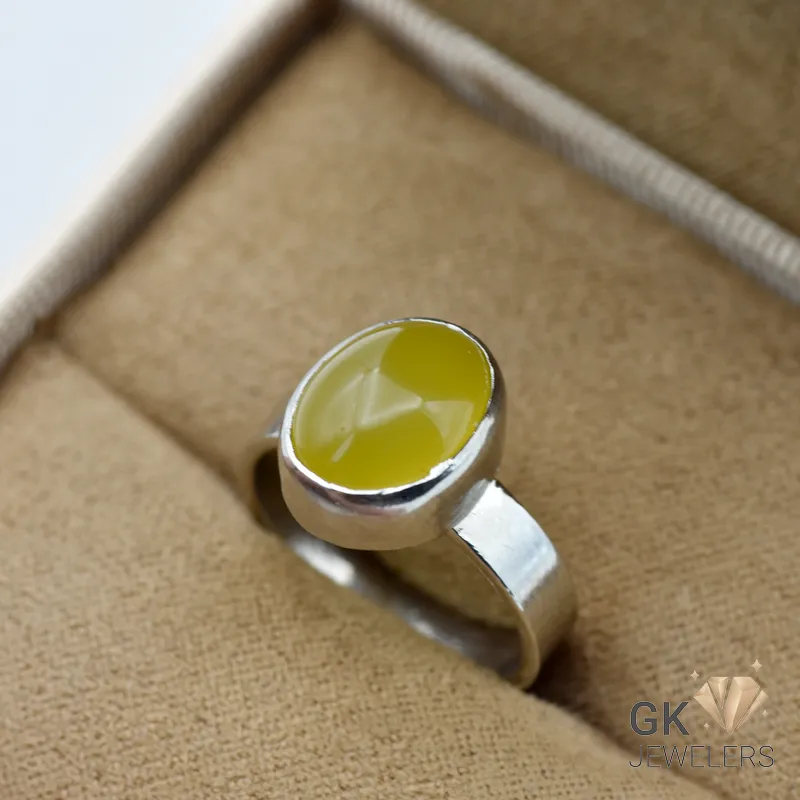 Yellow oval-cut natural Agate gemstone set in handmade sterling silver bezel ring, displayed on tan velvet jewelry box