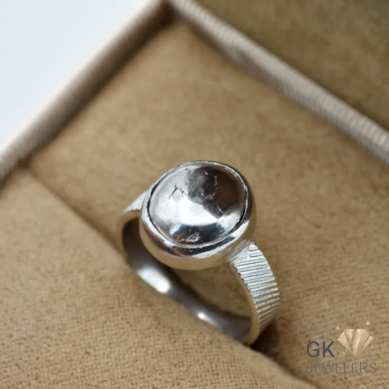 Silver ring featuring a round, gray pyrite gemstone with metallic luster, set in a handmade silver bezel setting, displayed in a jewelry box