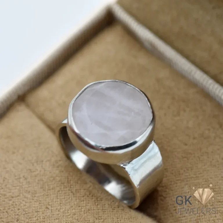 Silver ring featuring a round, semi-translucent rose quartz gemstone with a soft pink hue, set in a handmade bezel setting