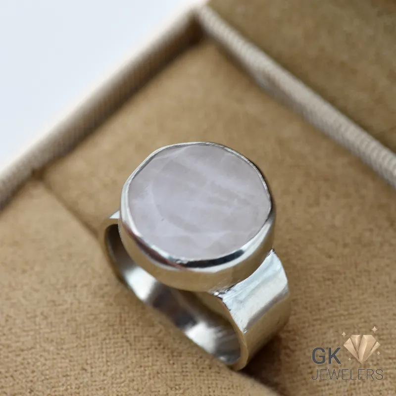 Silver ring featuring a round, semi-translucent rose quartz gemstone with a soft pink hue, set in a handmade bezel setting