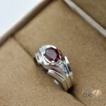 Silver ring featuring a vibrant red oval-cut natural garnet gemstone from Africa, set in a handmade silver band with geometric accents