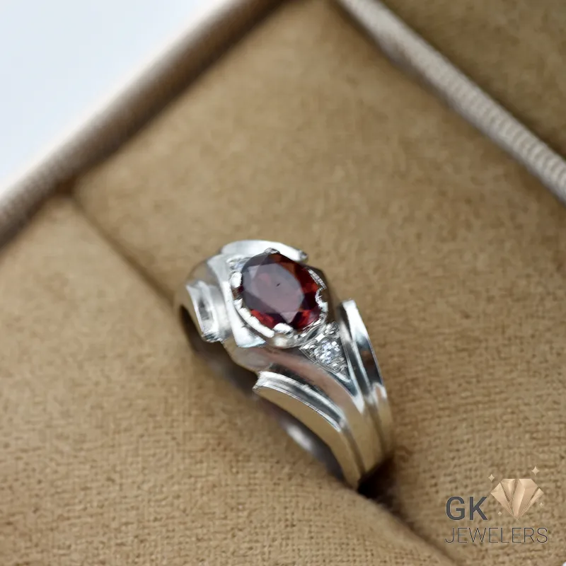 Silver ring featuring a vibrant red oval-cut natural garnet gemstone from Africa, set in a handmade silver band with geometric accents