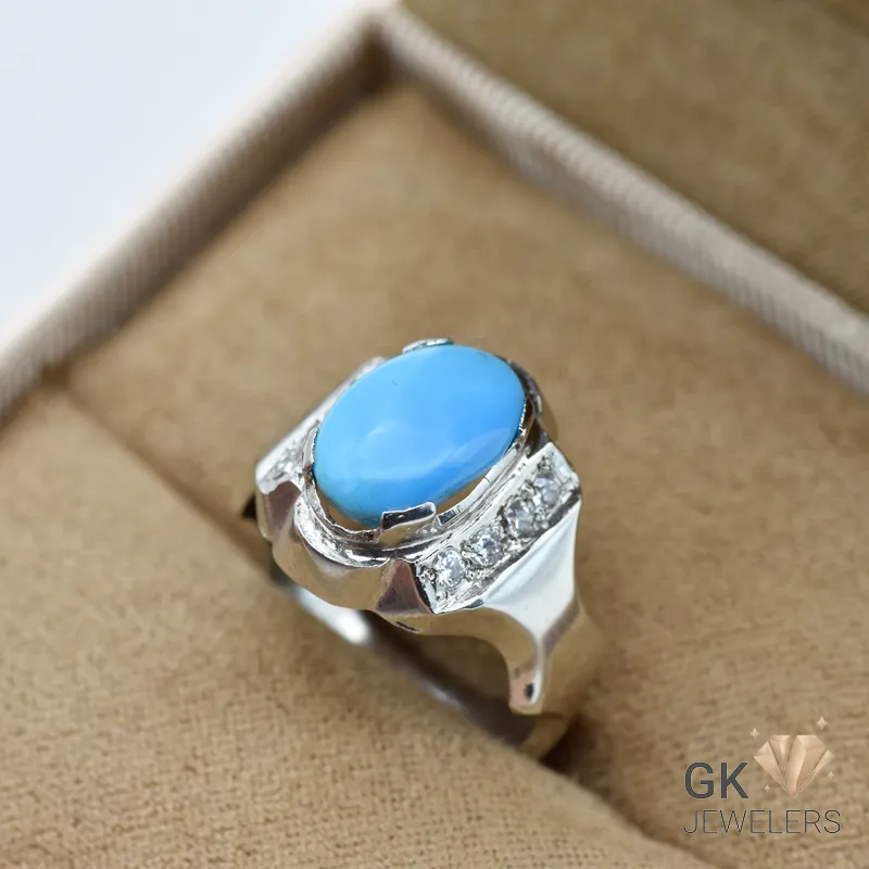 Oval blue turquoise gemstone in handmade silver ring with diamond accents, size 16, displayed in beige jewelry box