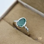 Oval-cut Zambian emerald gemstone set in 925 sterling silver ring, displayed in a jewelry box
