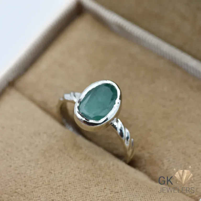 Oval-cut Zambian emerald gemstone set in 925 sterling silver ring, displayed in a jewelry box