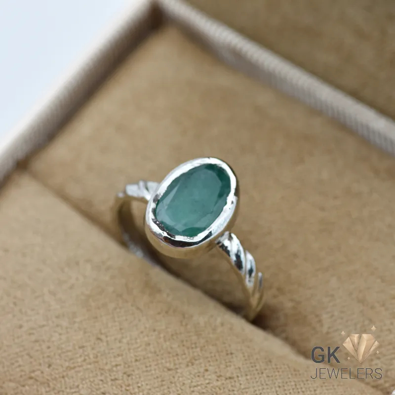 Oval-cut Zambian emerald gemstone set in 925 sterling silver ring, displayed in a jewelry box