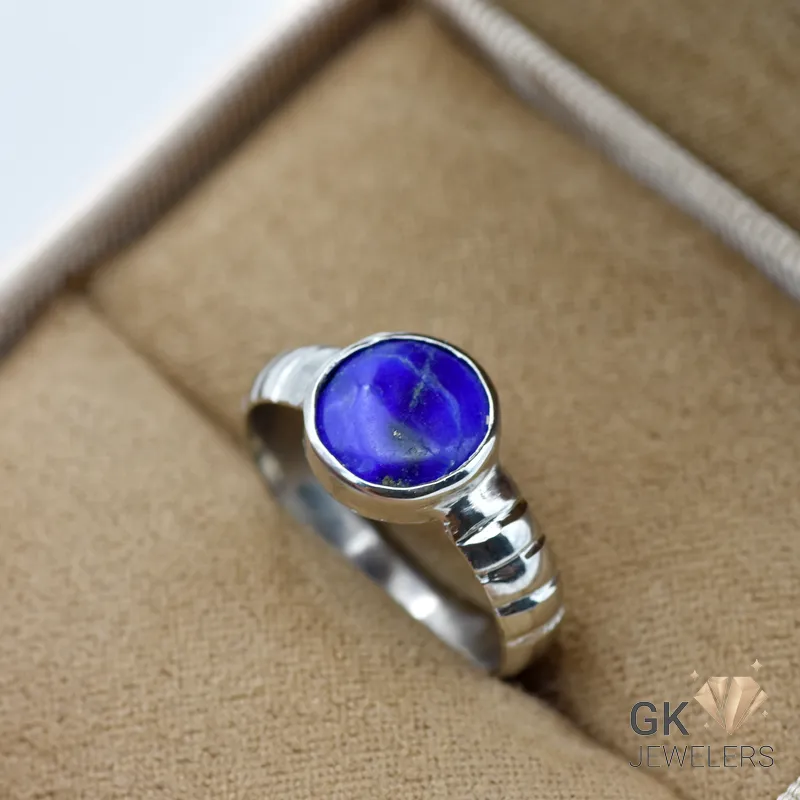 Handmade silver ring featuring a round, opaque blue lapis lazuli gemstone with golden flecks, crafted in Afghanistan