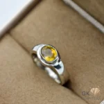 Oval-cut yellow sapphire gemstone set in a handmade silver ring, showcasing transparent color and premium craftsmanship