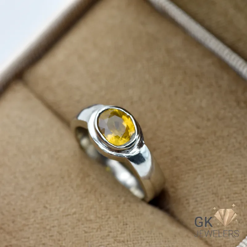 Oval-cut yellow sapphire gemstone set in a handmade silver ring, showcasing transparent color and premium craftsmanship