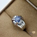 Silver ring featuring a large, oval-cut blue sapphire gemstone in a handmade setting