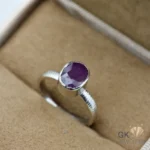 Silver ring featuring an oval-cut natural ruby gemstone from Madagascar, displayed in a cream-colored jewelry box