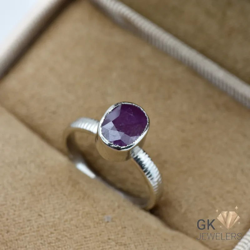 Silver ring featuring an oval-cut natural ruby gemstone from Madagascar, displayed in a cream-colored jewelry box
