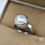 Sterling silver ring featuring a white natural pearl set in a bezel setting, displayed on a beige jewelry box fabric