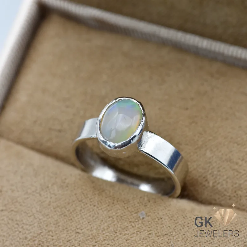 Silver ring featuring an oval Ethiopian opal gemstone with semi-transparent green hues, handmade setting, size 16