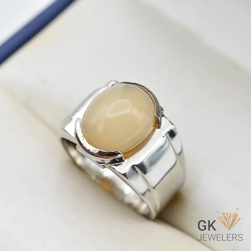 Oval-shaped natural opal gemstone set in a handmade sterling silver ring, displaying multiple colors and translucent clarity