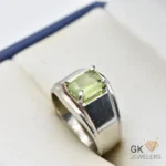Silver ring featuring a transparent emerald-cut peridot gemstone from Afghanistan, set in a four-prong setting with a polished band